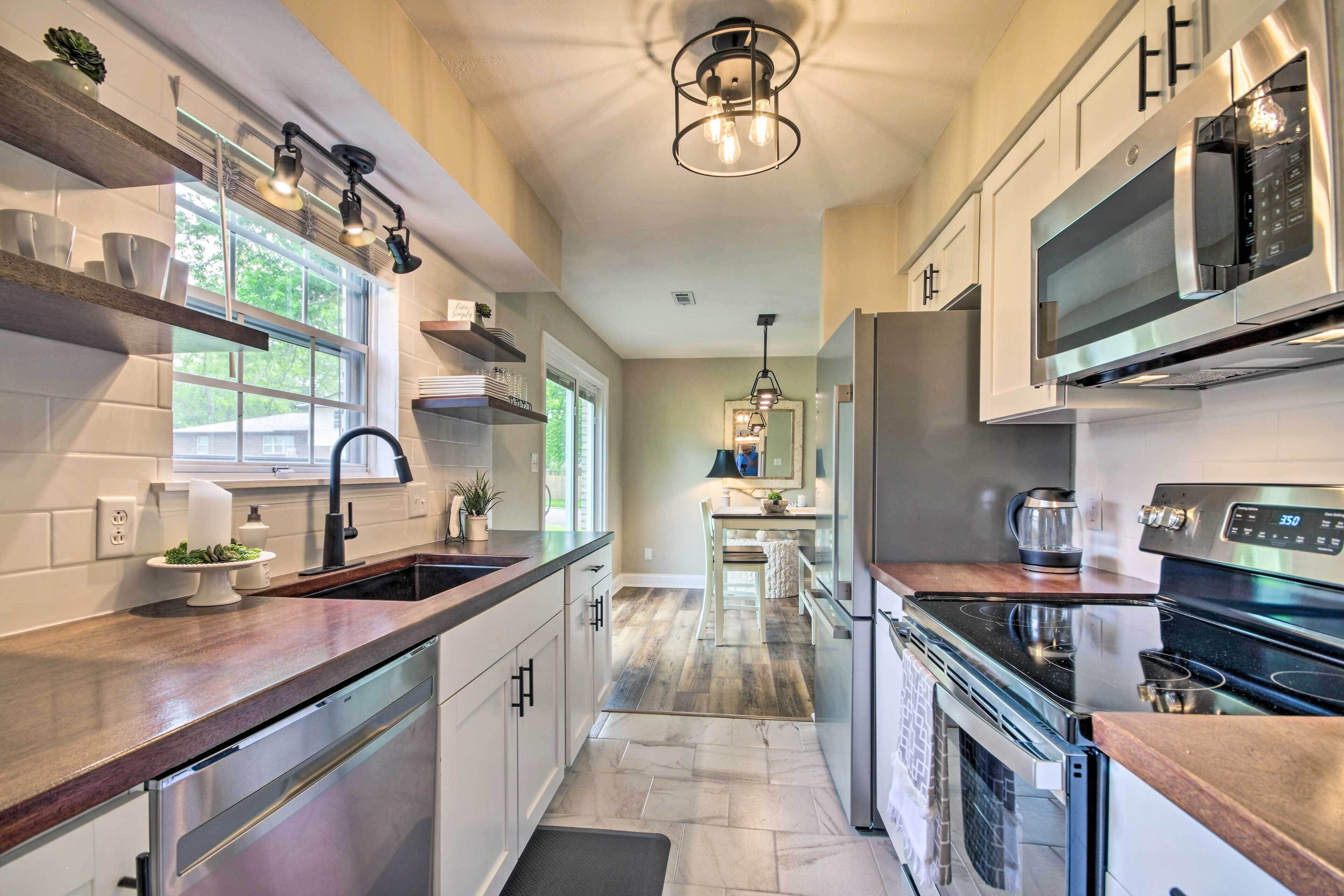 A modern kitchen with stainless steel appliances, wooden countertops, and a central island.