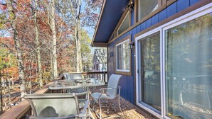 A deck with outdoor furniture, a glass table, and chairs, surrounded by trees with autumn leaves. - < 7 Mi to Slopes: Inviting Pocono Mtn Retreat! (Albrightsville)