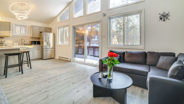 A spacious living area with a large window, a kitchen with modern appliances, and a cozy seating area. - < 7 Mi to Slopes: Inviting Pocono Mtn Retreat! (Albrightsville)