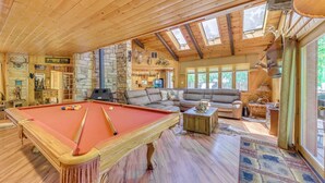 A wooden interior with a pool table, a sofa, and stone walls. - Deck & Hot Tub Bear Country Cabin, Upper Canyon (Ruidoso)