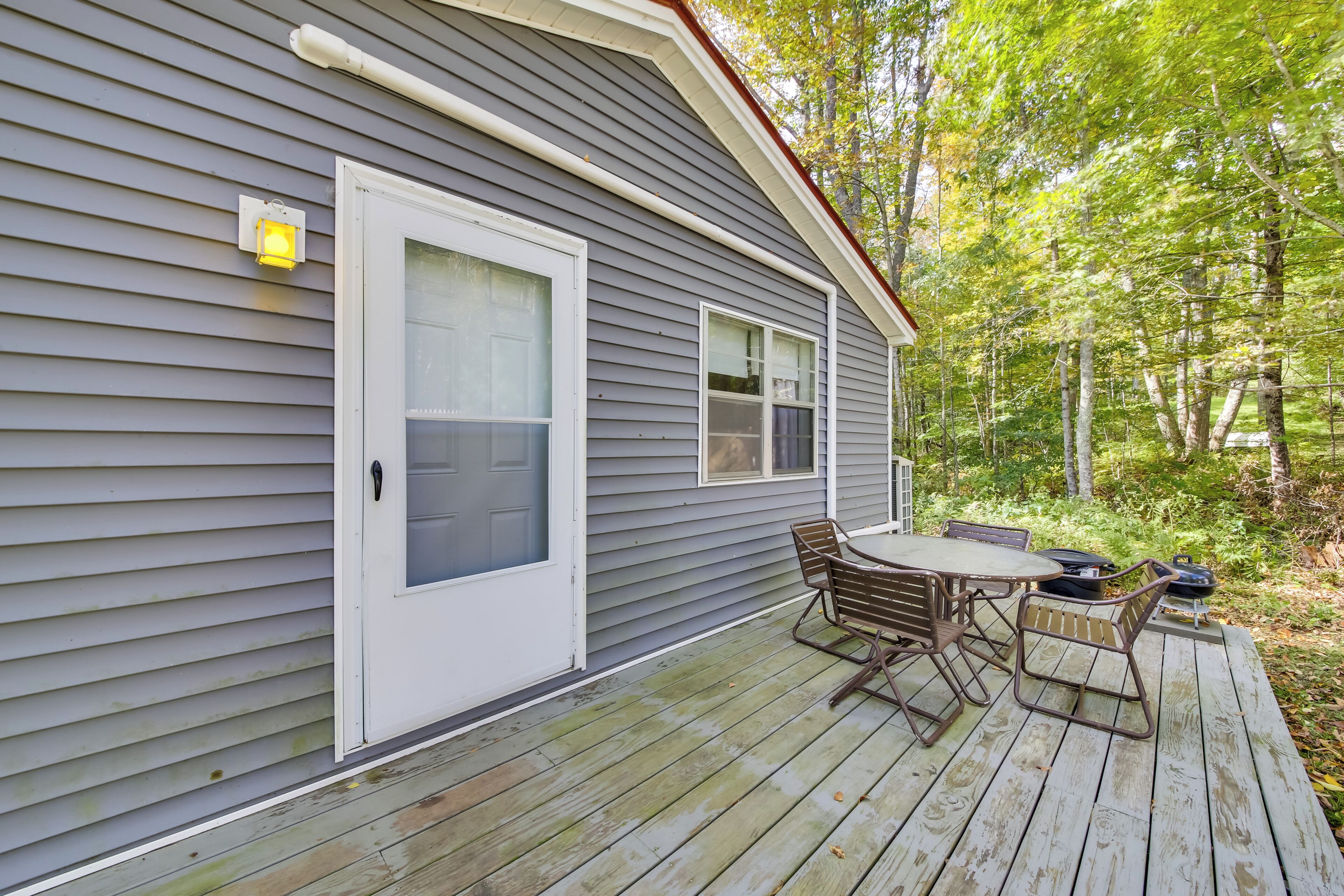 A house with a deck, a door, and windows.