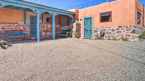 A building with a stone facade, a blue door, and a small porch area.