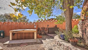 A patio area with a hot tub, outdoor seating, and a stone pathway.