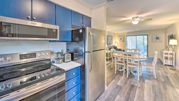 Una cocina moderna con armarios azules, un refrigerador de acero inoxidable y un horno empotrado.