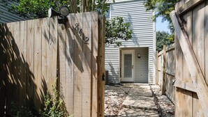 A wooden gate with a house number 8412, a pathway leading to a door, and a wooden fence. - Baton Rouge Townhome w/ Pool Access - 7 Mi to Lsu! (Baton Rouge)