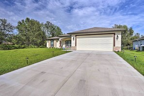 A residential house with a large garage, a well-maintained lawn, and a clear sky. - Private Heated Pool, Near Warm Mineral Springs (North Port)
