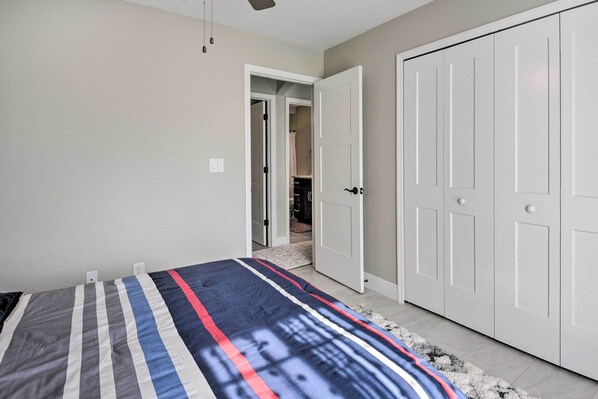 A bedroom with a bed, a wardrobe, and a door leading to a bathroom. - Private Heated Pool, Near Warm Mineral Springs (North Port)