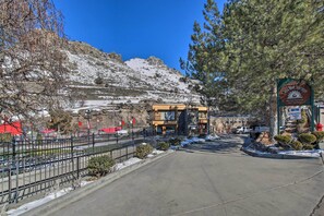 A hotel entrance with a snow-covered mountain backdrop, a parking area, and a sign indicating handicapped parking.
