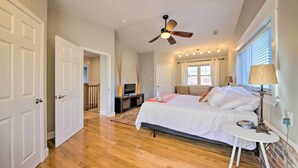 A bedroom with a bed, a ceiling fan, a bedside table, and a TV. - Stylish St. Louis Retreat w/ Great Location! (St. Louis)