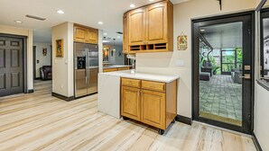 Una cucina moderna con mobili in legno, un frigorifero integrato e una grande isola con lavello.