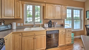 A kitchen with wooden cabinets, a dishwasher, a toaster, and a sink. - Waterside Haven on Milton Pond w/ Deck & Boat Dock (Milton)