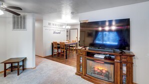A living room with a fireplace, a TV, and a dining area. - Peaceful Nature Escape w/ Deck in North Pole! (North Pole)