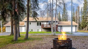 A two-story building with a fire pit in the foreground. - Peaceful Nature Escape w/ Deck in North Pole! (North Pole)