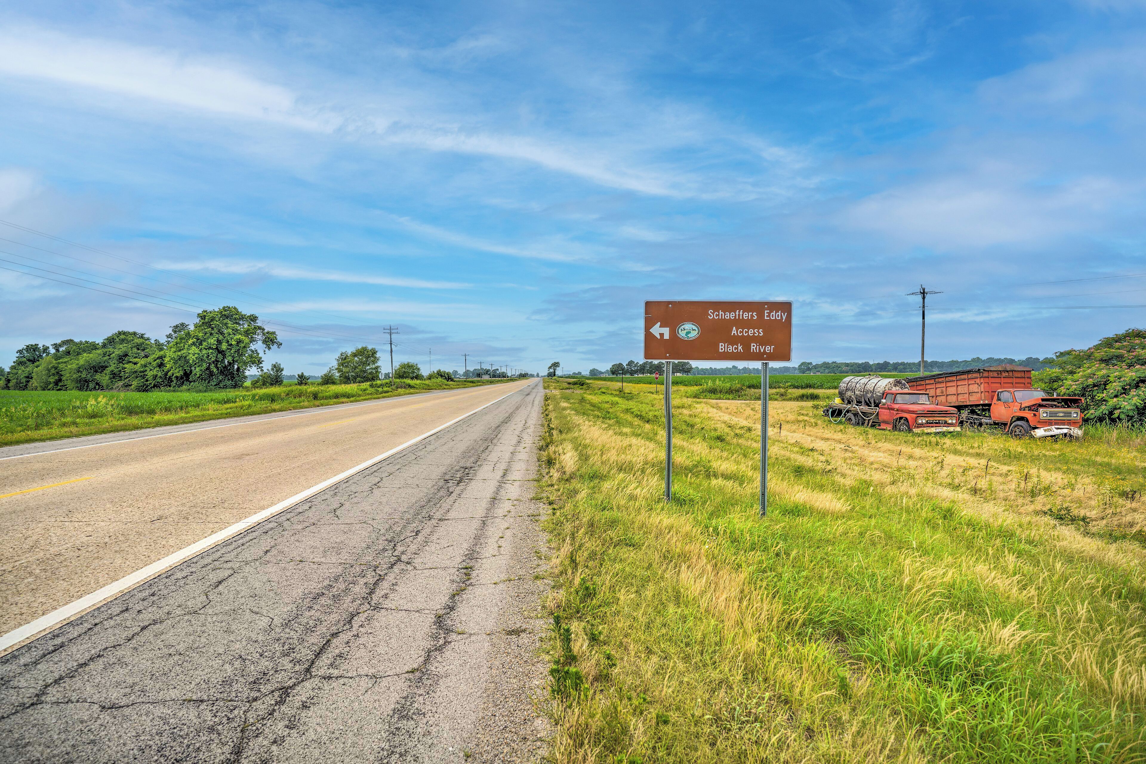 A rural road with a directional sign indicating Schaeffers Eddy, Access, and Black River.