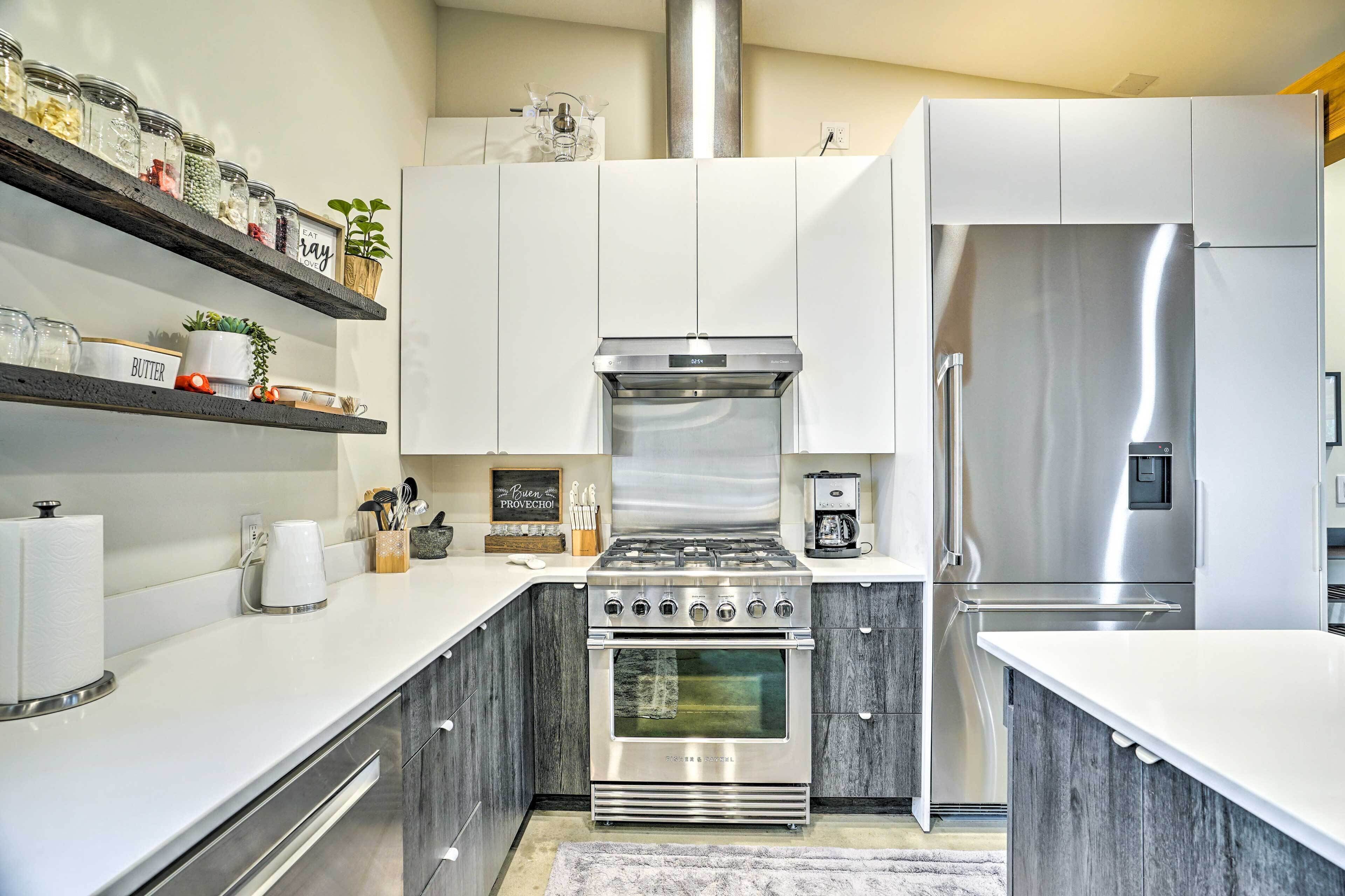 A modern kitchen with white cabinets, a stainless steel stove, and a refrigerator.