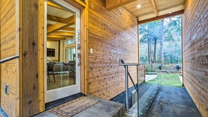 Ein Holzfassade mit einer Glastür, die zu einem modernen Innenraum führt.