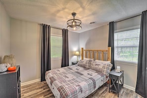 A bedroom with a bed, a nightstand, a lamp, and a window with curtains. - Deep Gap Cottage w/ Fire Pits - Hike & Ski! (Deep Gap)