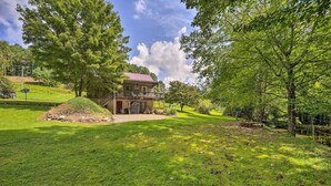 A house with a balcony, surrounded by lush green grass and trees. - Deep Gap Cottage w/ Fire Pits - Hike & Ski! (Deep Gap)