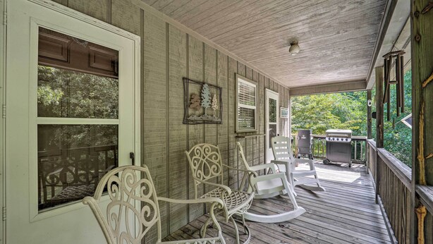 A covered porch with rocking chairs, a grill, and a view of the surrounding greenery. - Deep Gap Cottage w/ Fire Pits - Hike & Ski! (Deep Gap)