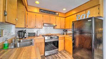 A kitchen with wooden cabinets, stainless steel appliances, and a sign that says "eat."