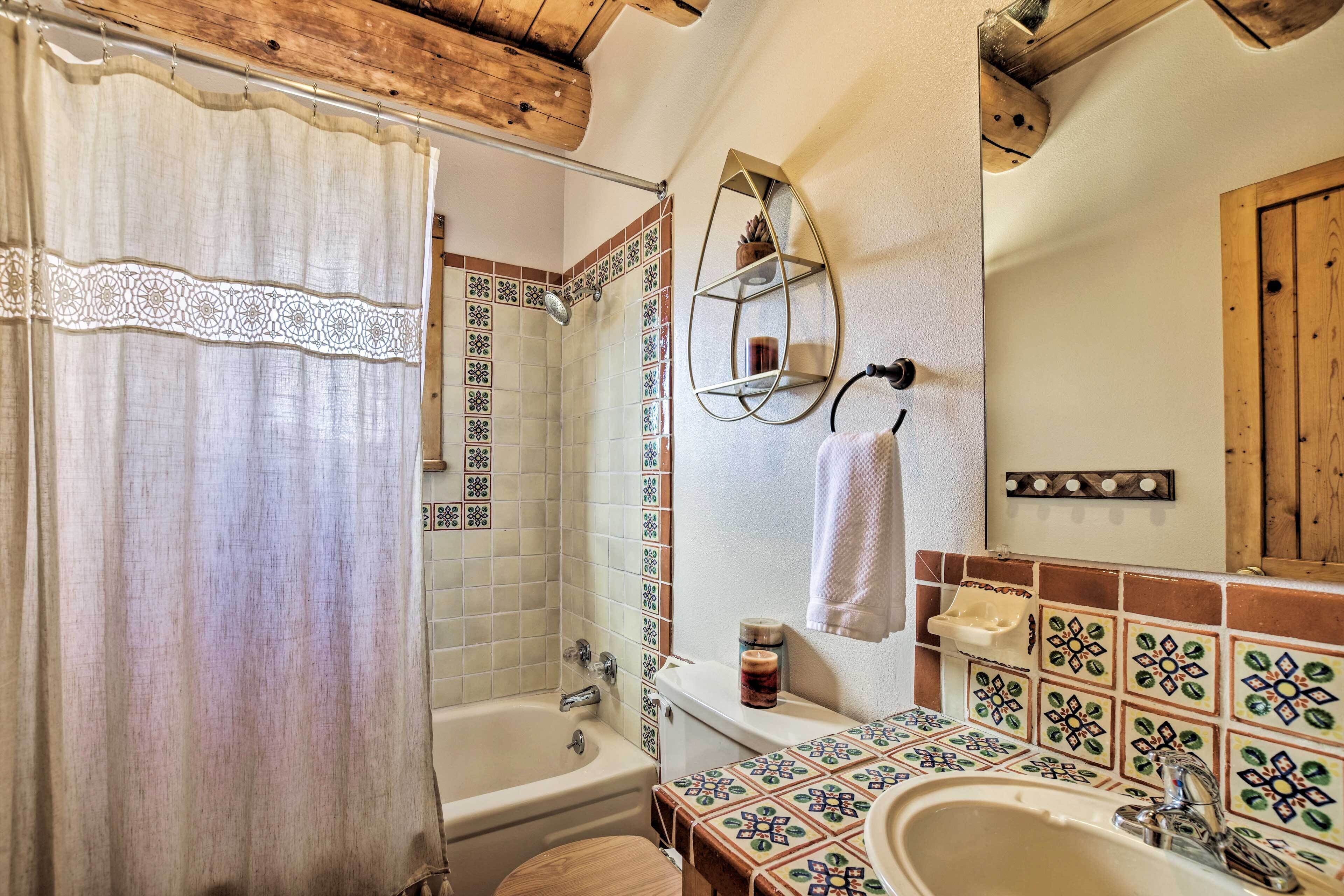 Un baño con ducha, bañera, lavabo y espejo.
