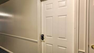 A white door with a keyhole and a doorbell.