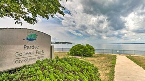 Placa indicando o Parque Parde Seawall em New Haven, com vista para a água e um céu nublado.