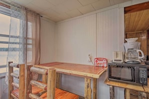 A rustic kitchen with a wooden table, a microwave, and a coffee maker. - Lakefront Minocqua Cabin w/ Dock & Fire Pit! (Minocqua)