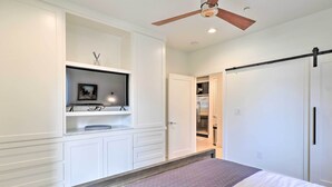 A bedroom with a bed, a ceiling fan, built-in shelving, and a wardrobe. - Lake LBJ Condo w/ Balcony & Shared Boat Docks (Horseshoe Bay)