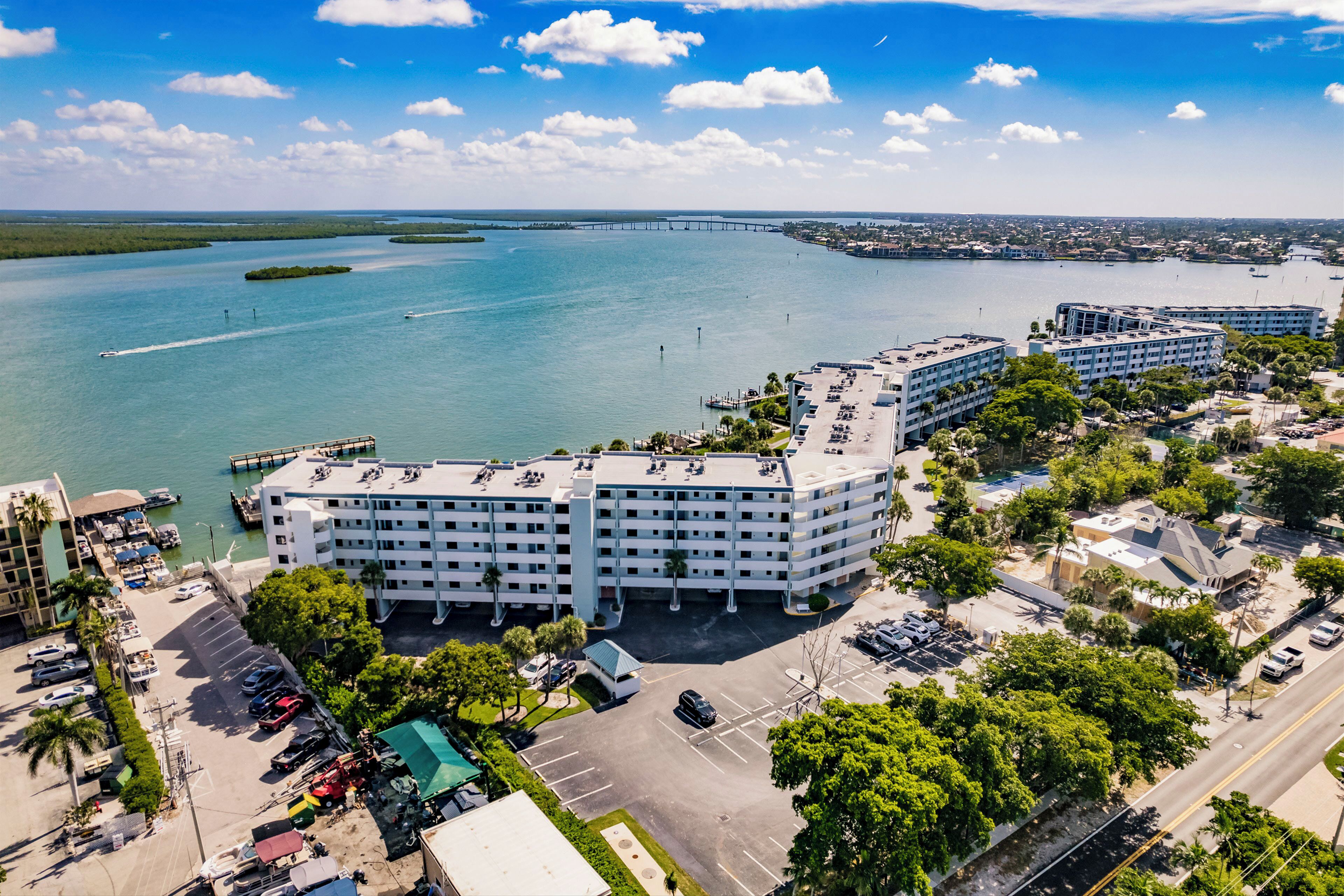 A multi-story hotel with a parking lot and a marina.