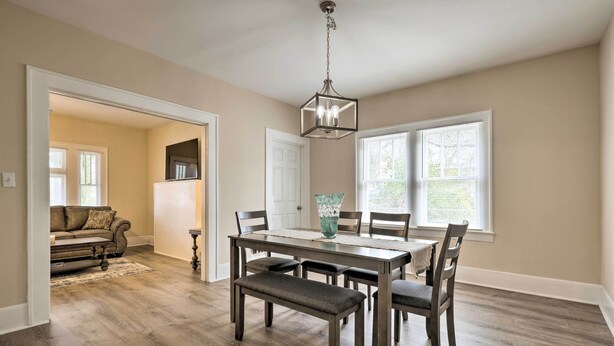 A dining area with a wooden table, six chairs, and a bench. There is a chandelier above the table. - Inviting Home, 1 Mi to High Point University! (High Point)