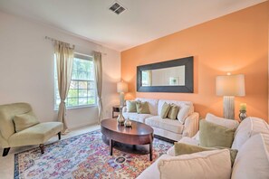 A living room with a sofa, armchair, coffee table, and patterned rug. - 13 Mi to Parks: Davenport Home w/ Pool & Game Room (Davenport)