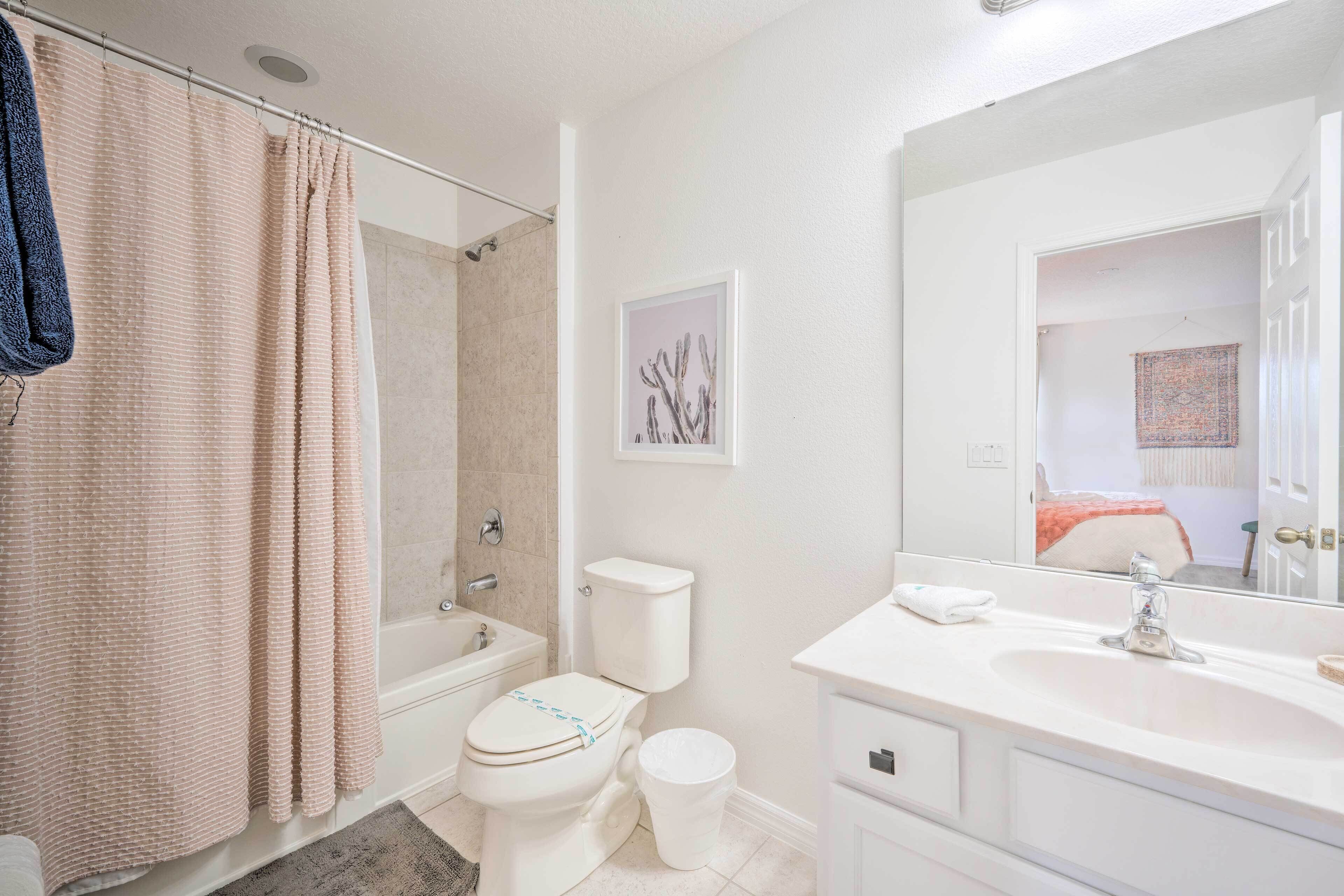 A bathroom with a bathtub, toilet, and sink.