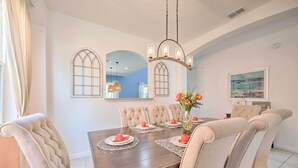 Un comedor con una mesa de madera dispuesta para cuatro personas, rodeada de sillas tapizadas.