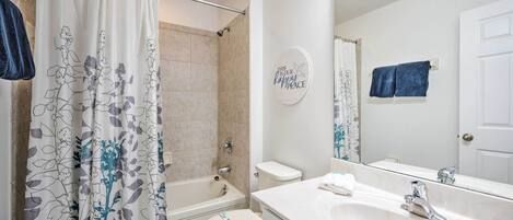 A bathroom with a bathtub, toilet, and sink.