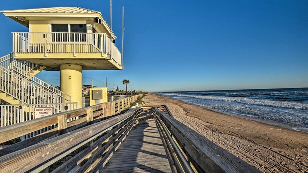 A lifeguard tower with a wooden walkway leading to the beach. - Pet-friendly Ormond Beach Home w/ Fire Pit! (Ormond Beach)