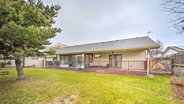 A single-story house with a covered porch, a fenced yard, and a large tree. - Pet-friendly Caldwell Home Rental Near Lake! (Caldwell)