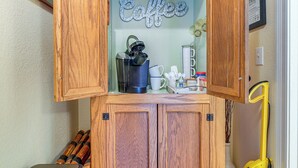 Un meuble en bois contenant une machine à café et des tasses.