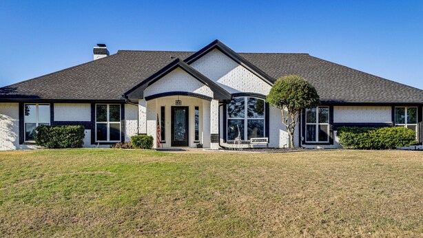 A two-story house with a gabled roof, a front porch, and a well-maintained lawn. - Granbury Studio - 10 Mins From Town + The Lake! (Granbury)