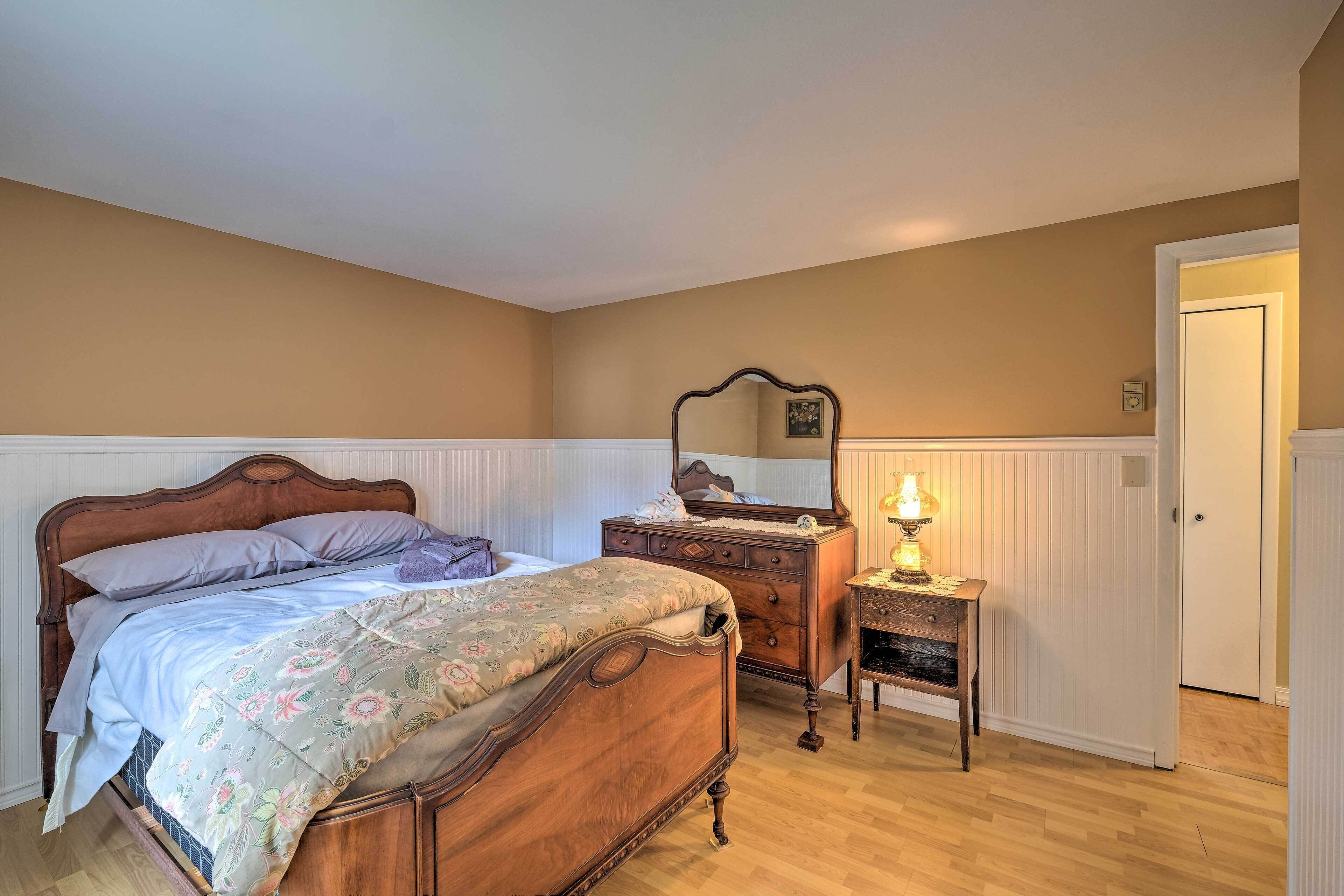 Une chambre à coucher avec un lit en bois, une commode et une table de chevet.