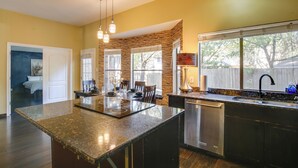 A modern kitchen with a central island, built-in appliances, and large windows. - Family-friendly San Antonio Abode w/ Patio! (San Antonio)