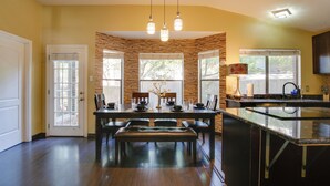 A modern kitchen with a central island, built-in stone walls, and a dining area with a bench. - Family-friendly San Antonio Abode w/ Patio! (San Antonio)