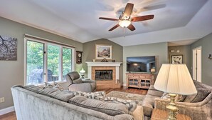 A living room with a fireplace, a ceiling fan, and a television. - Lakefront Getaway w/ Private Dock & Kayaks! (Bella Vista)