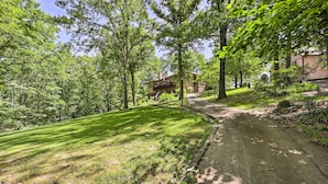 A residential area with a well-maintained lawn, a paved pathway, and a two-story house with a balcony. - Lakefront Getaway w/ Private Dock & Kayaks! (Bella Vista)