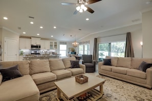 A spacious living room with two beige sofas, a coffee table, and a ceiling fan. - Cozy St Augustine Bungalow < 7 Mi to Beaches! (St. Augustine)