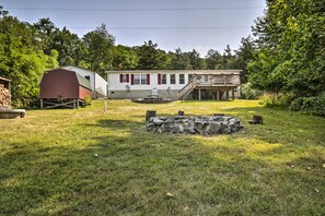 A two-story house with a covered porch and a stone retaining wall in the yard. - Shenandoah River Getaway < 9 Mi to Downtown Luray! (Rileyville)