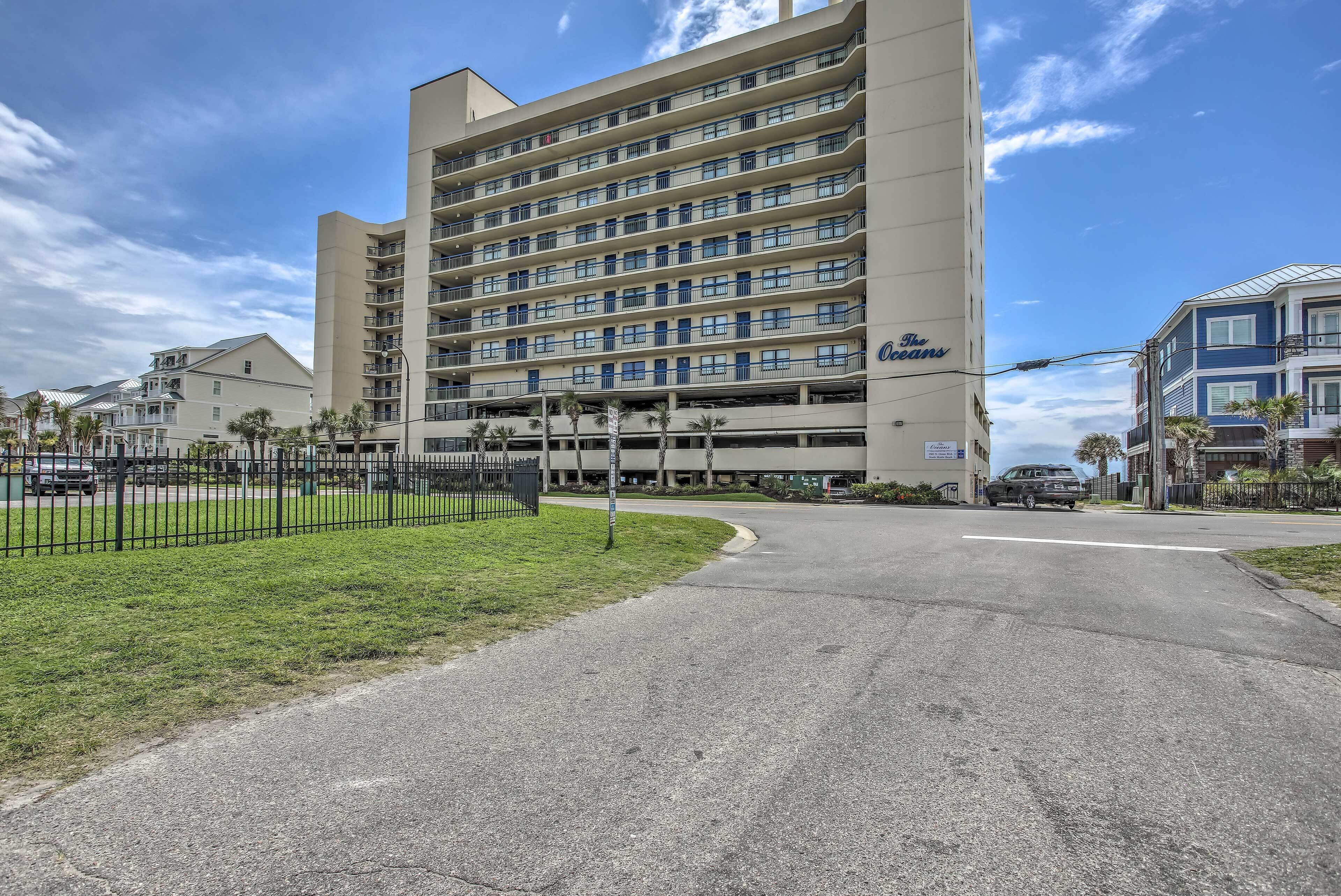 A multi-story hotel with a flat facade, multiple balconies, and a parking garage.