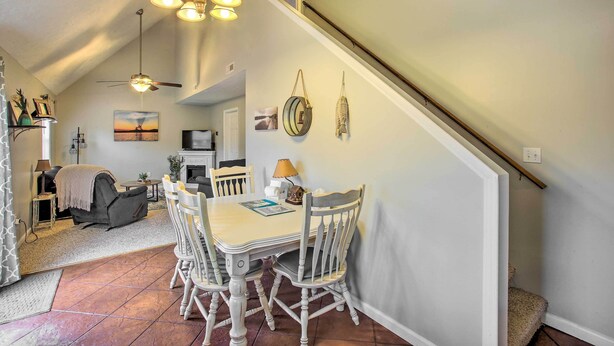 Un espace repas comprenant une table et des chaises, un ventilateur de plafond et des lampes fixées au mur.