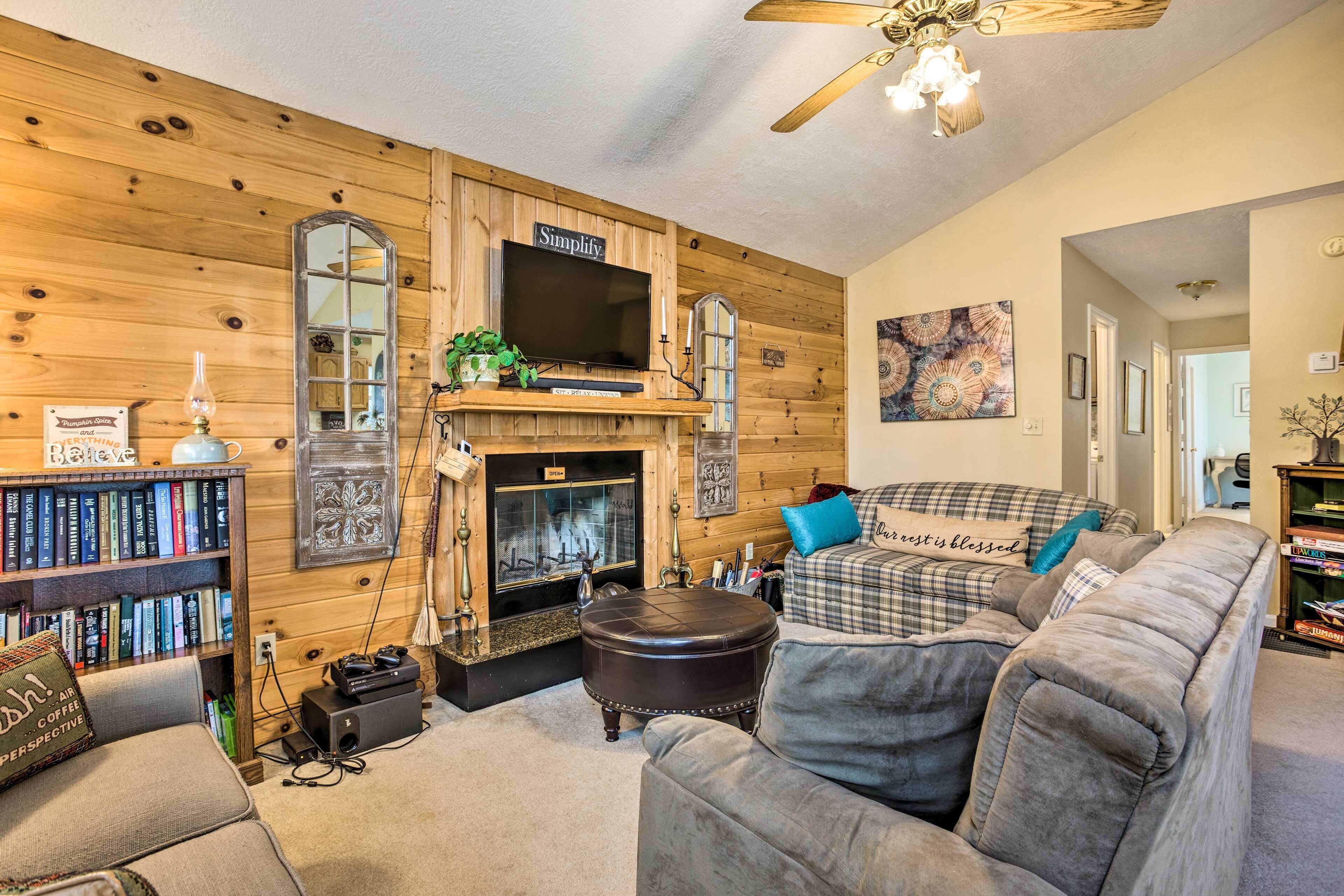 A cozy living room with a fireplace, a television, and a couch.