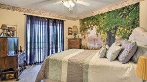A bedroom with a large bed, a ceiling fan, a dresser, a nightstand, and a wall mural. - Bring a Pet: Cozy Burnsville Cottage w/ Fire Pit! (Burnsville)
